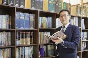小林弁護士が本を持っている写真